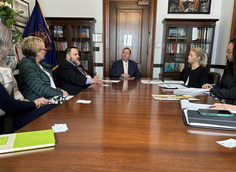Image of Gustavo meeting with legislators at a table