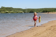 Little Girl in a Pink Swimsuit Walking Along the Shoreline of Millennium Beach