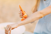 Woman Applies Sunscreen to Her Arm