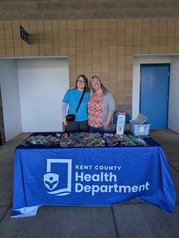 Two Kent County Health Department Employees Tabling an Outreach Event at the West Michigan Whitecaps Game