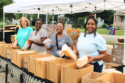 Image of four women doing food distribtution