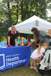 People Stopping by a Health Department Table During a Community Event