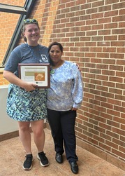Last Month's People's Champion Award Recipient, RosaRodriguez, Hands Off Award to Lindsey Huizenga
