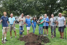 Commissioner Ponstein and a group of people in front of the tree