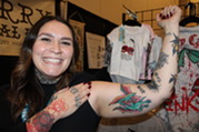 Photo of a Woman Flexing Her Bicep to Show Off a Colorful Tattoo at the Grand Rapids Tattoo Festival