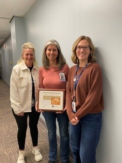 Registered Dietitians Sam Samuels and Jenn Sowle Presenting October's People's Champion Award to Public Health Nurse Jami Richardson