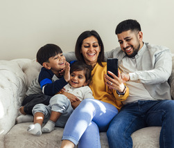 Family on couch looking at computer together