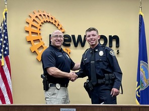 New officer Chris Brown shakes hands with Chief Craig Dunlavy