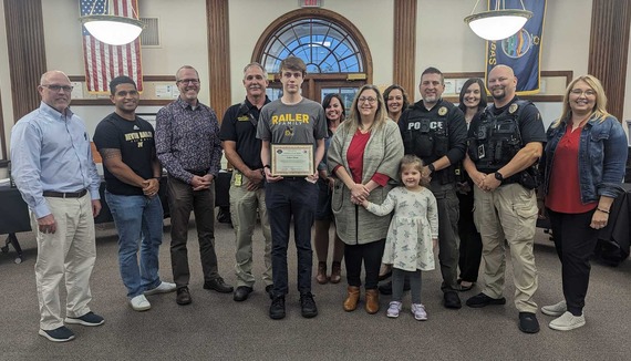 Hero student Ethan House poses with school board and emergency responders