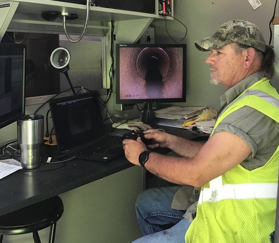 Maintenance worker televising a sewer line