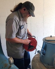 Josh Chastain checking water levels at well
