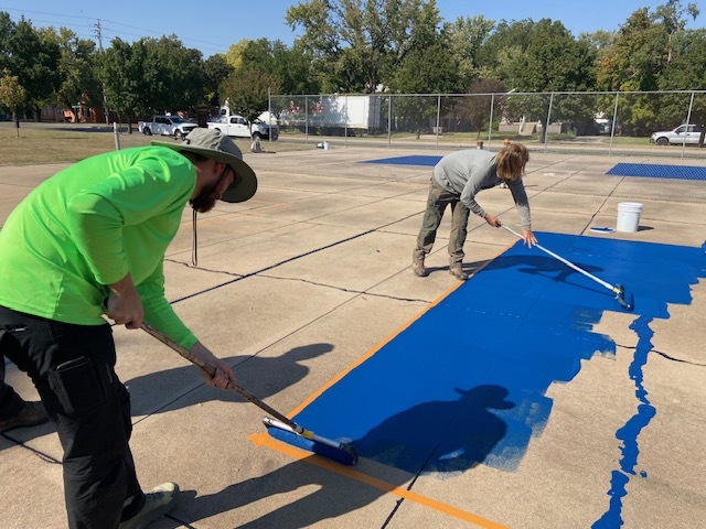 Parks staff painting pickleball court