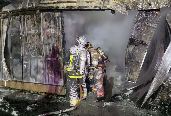 Firefighters in burned shed