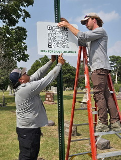 City staff installing sign for new searchable cemetery software
