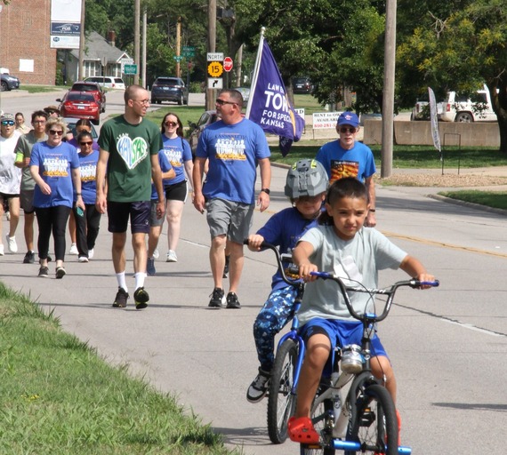 Special Olympics athlete Lance Welch and Newton Police Officer Stan Kurtz visit as they walk in the Torch Run