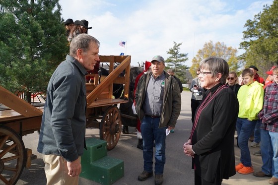 Governor Kelly receives the Christmas tree as it's pulled on a horse-drawn carriage