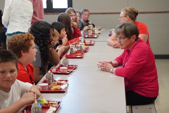 Governor Kelly talks to students while they eat lunch