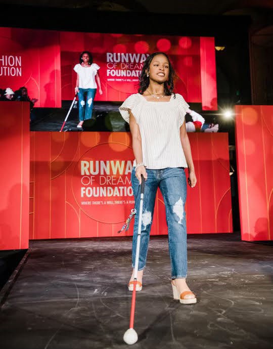 A girl walks on a fashion show runway