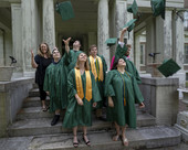 A photo of students in caps and gowns smiling, throwing their caps in the air