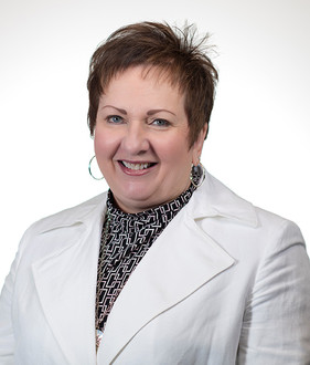Picture of a smiling woman wearing a suit.