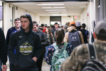 Picture of a group of students walking down a school hallway.