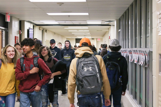Several students walk through a hallway