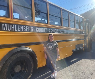 Rachel Embry standing in front of a Muhlenberg County School Bus.