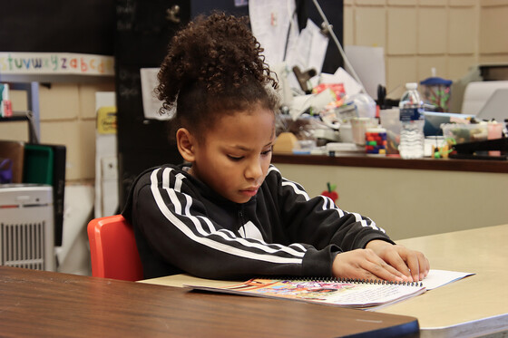 A child reads a book in braille
