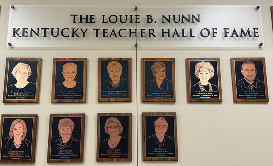 Several plagues with faces engraved on them are on a wall with the words "The Louis B. Nunn Kentucky Teacher Hall of Fame" written above them
