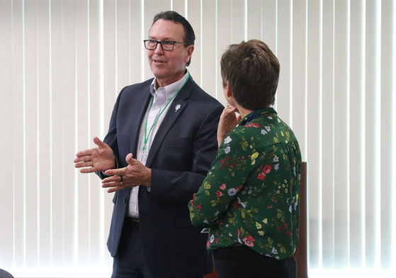 Jim Flynn gestures while talking to a woman on the Kentucky United We Learn Council.