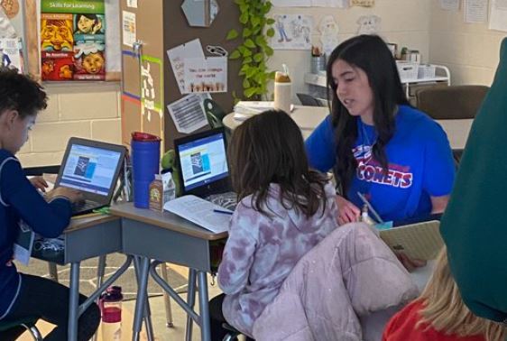 Teacher working with student on computer