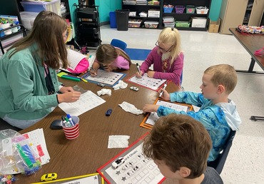 Students at small group table with dry erase sleeves