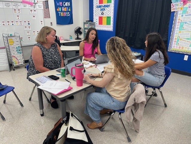 Teachers sitting at table collaborating