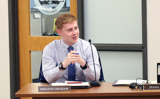 Preston Graham sitting at a table during a Kentucky Board of Education meeting