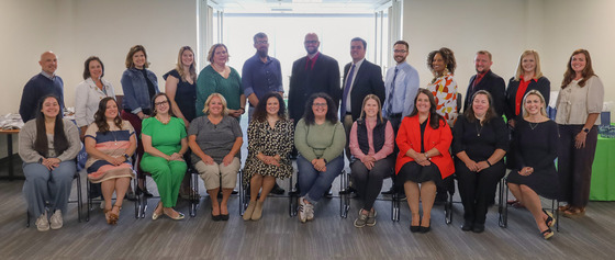 Group of teachers sitting and standing in a team oriented picture.