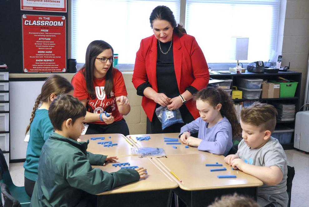teacher working around a table with students
