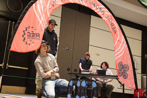 Students competing in an indoor drone obstacle course