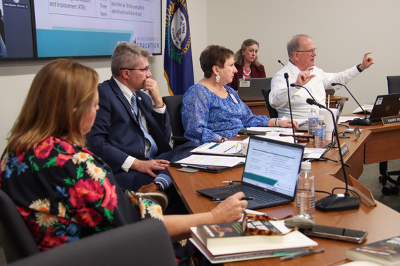 Adults featuring the KDE commissioner and Kentucky Board of Education members sitting at a table with microphones addressing the crowd