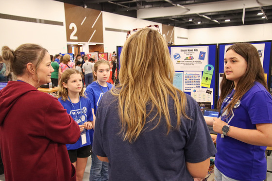 A group of kids present a project to two judges