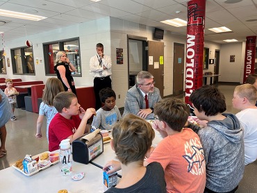 Commissioner of Education Robbie Fletcher sits with students in at a lunchtable