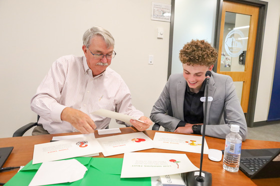 Two individuals sitting at a table working on a group project.