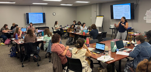 Educators sit in a room together for a professional learning session