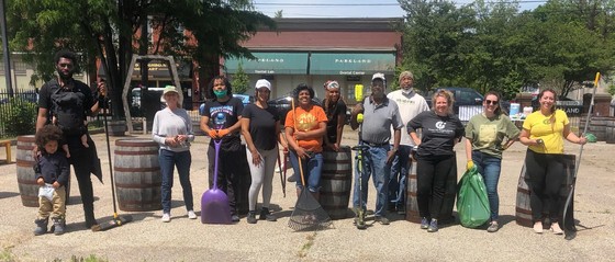 Photo of 13 people who participated in the cleanup, tools and bags in hand.