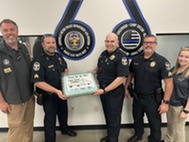 Ben and officers holding cake