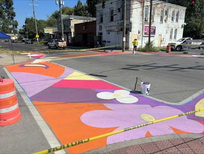 Photo: Intersection of greenwood and 28th, orange yellow and purple floral street art is on the crosswalks