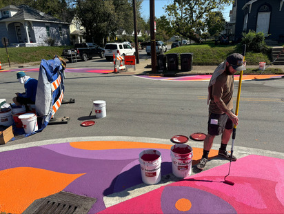 Photo: Intersection of  Grand and 28th, orange yellow and purple floral street art is on the crosswalks