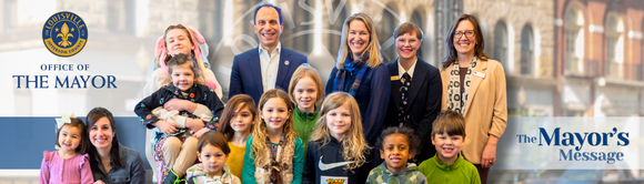 Image of officials, city workers, and children at a library