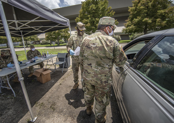 National Guardsman speaks to driver of a vehicle awaiting COVID testing