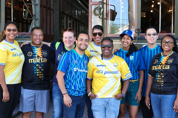 Group shot of visiting transit professionals in front of streetcars