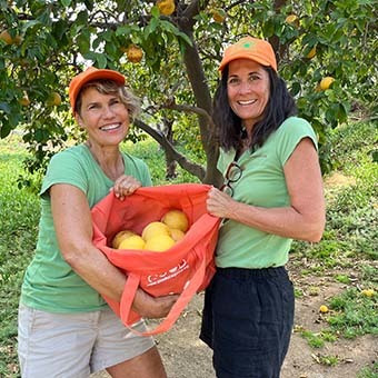 Women with barrels of oranges